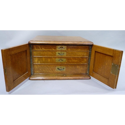 188 - An Edwardian oak chest canteen with brass inset side carrying handles, two indented panel doors, the... 