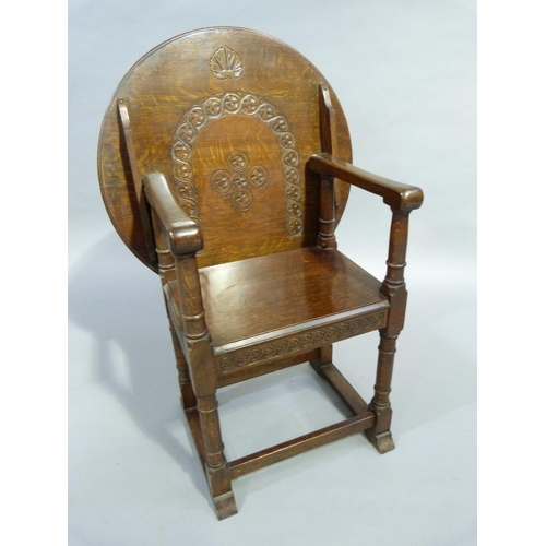 264 - A 1920/30's oak monks chair, the arch back carved with guilloche and folding over to create a table,... 