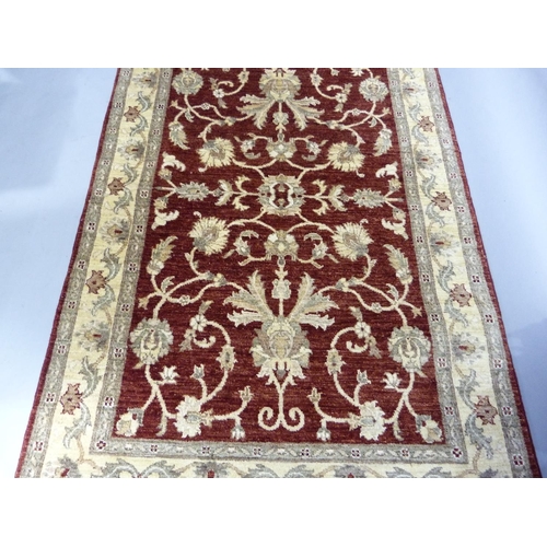 268 - A Ziegler design rug, made in Pakistan, measuring 1.87m x1.22m in crimson, ivory and camel