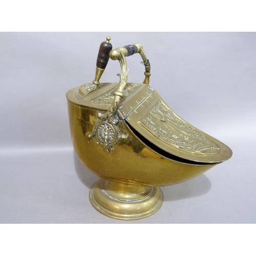 269 - An Edwardian brass coal scuttle of helmet shape with rising foliate cast brass handle with  turned w... 