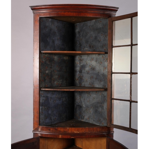 301 - A 19th century mahogany bow front standing corner cupboard, having a moulded cornice above a twelve ... 