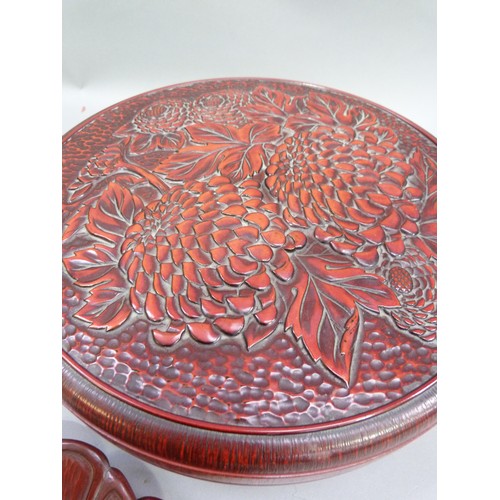 15 - A red lacquered hors d'oeuvre set in a pedestal stand with the cover moulded with chrysanthemum; tog... 