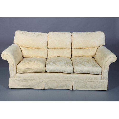 100 - A yellow cotton upholstered three seater sofa