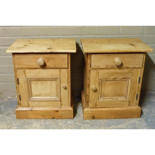 143 - A pair of pine bedside cupboards, the tops above one drawer and panelled cupboard on skirted plinths... 