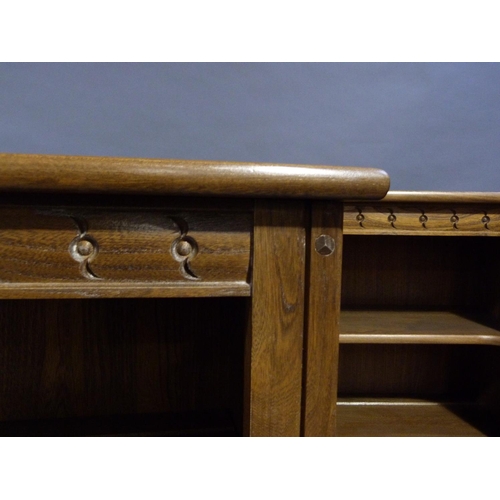 289 - A pair of Ercol elm book shelves having a carved freeze and on plinth base, each measuring 97cm x 15... 