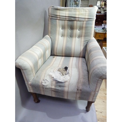 282 - A 19th century upholstered arm chair on turned legs with casters