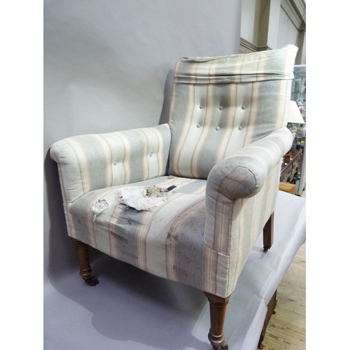 282 - A 19th century upholstered arm chair on turned legs with casters