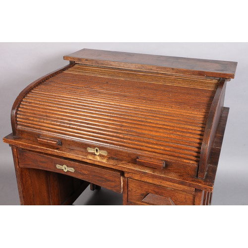 292 - An oak tambour fronted desk with fitted interior above a pedestal of four drawers flanked by a singl... 