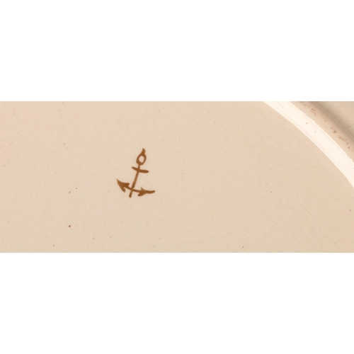 10 - A Creamware plate painted in the style of Chelsea with an exotic bird and tree in polychrome enamels... 