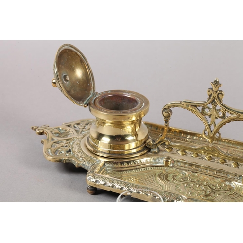13 - A Victorian brass double desk standish fitted with two glass lined inkwells, pierced handle and oppo... 