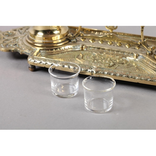 13 - A Victorian brass double desk standish fitted with two glass lined inkwells, pierced handle and oppo... 