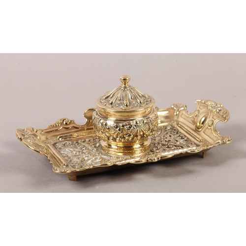 14 - A Victorian brass desk standish fitted with a central inkwell and cover cast with ribboned harebells... 