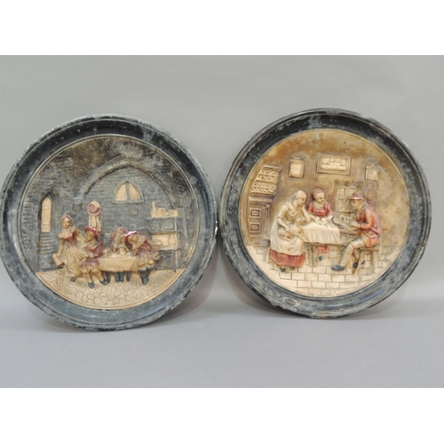 33 - A pair of pottery wall plaques, moulded in relief with figures in a tavern and figures around a kitc... 