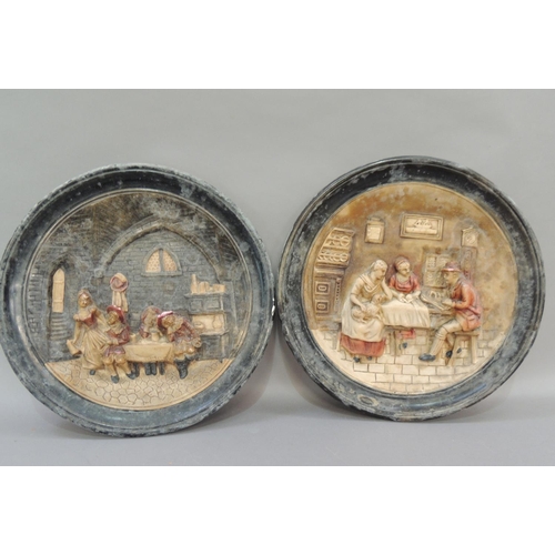 33 - A pair of pottery wall plaques, moulded in relief with figures in a tavern and figures around a kitc... 