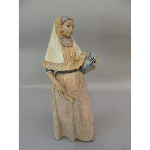 36 - A lladro figure of a young Spanish girl holding a picture beneath her left arm, a fan in her right h... 