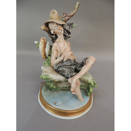 37 - A Naples porcelain figure of an elderly sleeping fisherman seated on the banks of a stream, 25cm hig... 