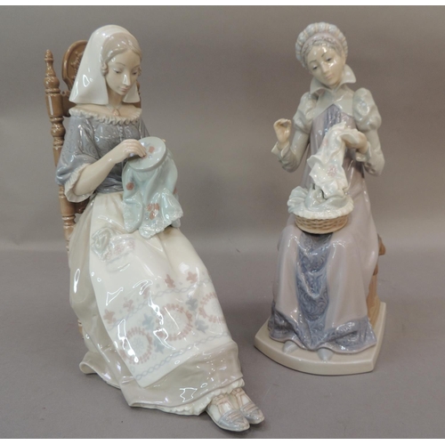 46 - A pair of Lladro porcelain figures of seated females both sewing, 28cm high approximately