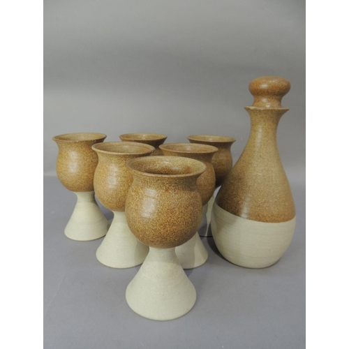 47 - A set of six studio pottery goblets and matching decanter, the glazed tulip shaped tops on buff pott... 