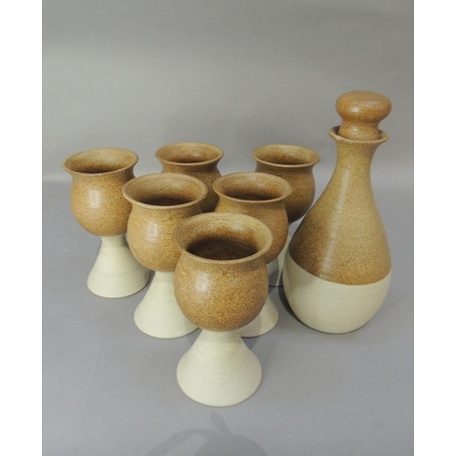 47 - A set of six studio pottery goblets and matching decanter, the glazed tulip shaped tops on buff pott... 