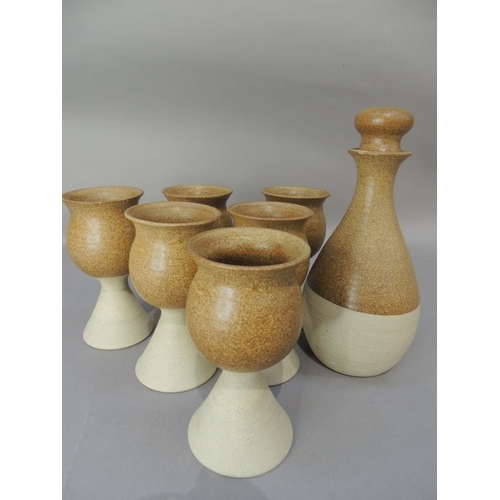 47 - A set of six studio pottery goblets and matching decanter, the glazed tulip shaped tops on buff pott... 