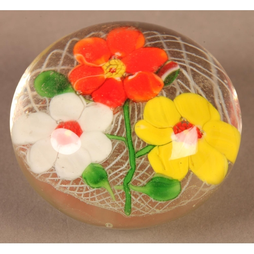 5 - A glass paperweight with white, yellow and orange flowers on a white latticino ground, ground base, ... 