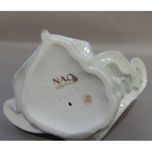 52 - A Nao porcelain figure of a young girl carrying a two handled vase under her arm with a bird perched... 