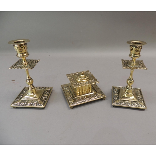 57 - A Victorian brass desk set comprising well and pair of candlesticks, the square ink well with foliat... 