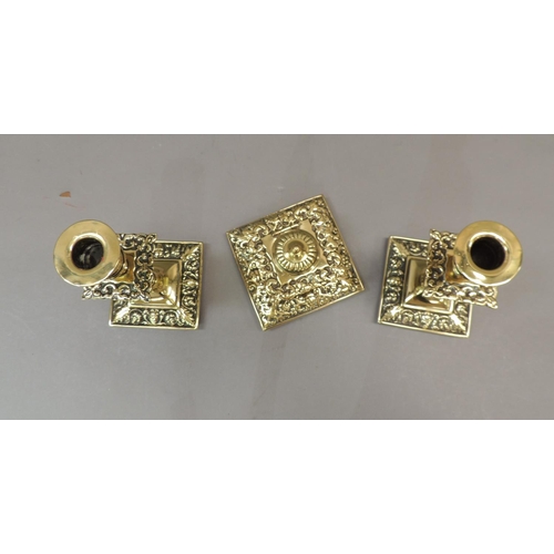 57 - A Victorian brass desk set comprising well and pair of candlesticks, the square ink well with foliat... 