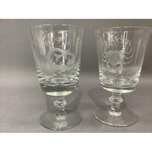 13 - A pair of glass goblets, etched with a crab the horoscope sign Cancer and a fish for Pisces, on a bl... 