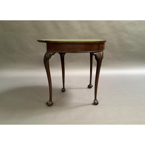 725 - A mahogany card table in George III style, the D-shaped top above a deep frieze on acanthus carved c... 