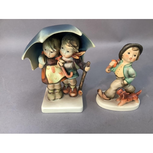 61 - A Hummel figure of boy and girl sheltering under a large umbrella, 15cm high together with a smaller... 