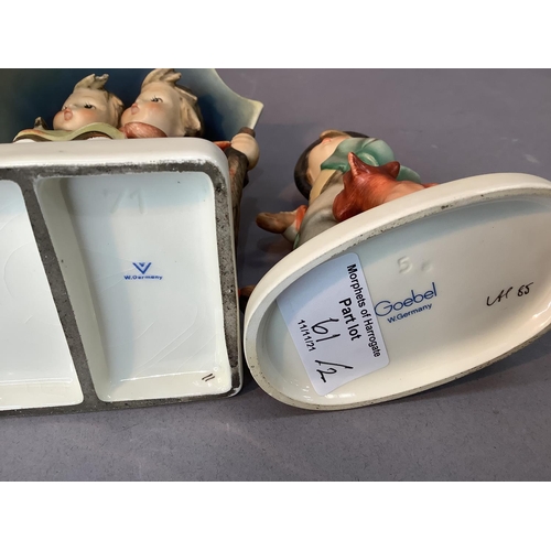 61 - A Hummel figure of boy and girl sheltering under a large umbrella, 15cm high together with a smaller... 