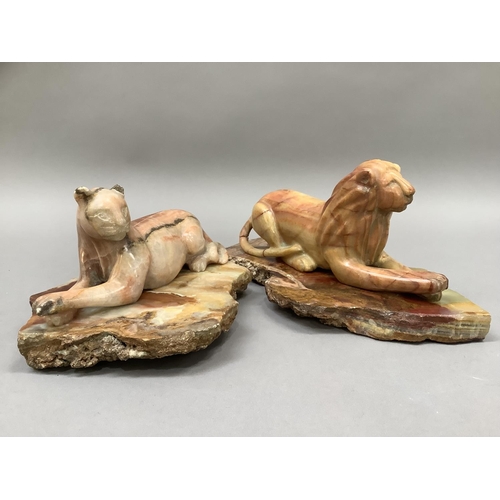 5 - A carved onyx lion and lioness each resting on a plinth of onyx, 11cm and 10cm high, plinths 24.5cm ... 