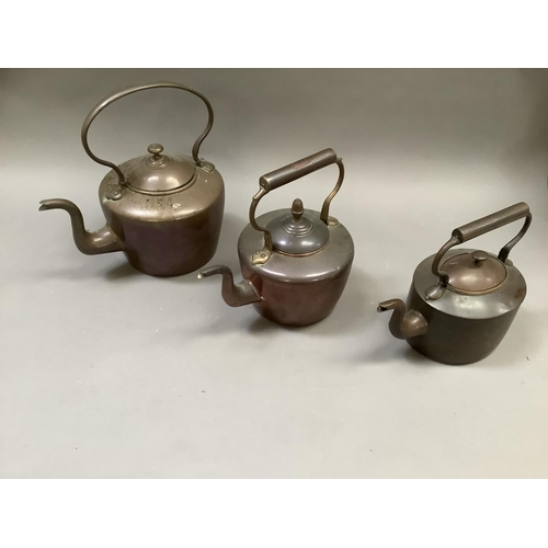 57 - Two copper kettles of circular outline, 32cm over handle and 28cm over handle together with another ... 