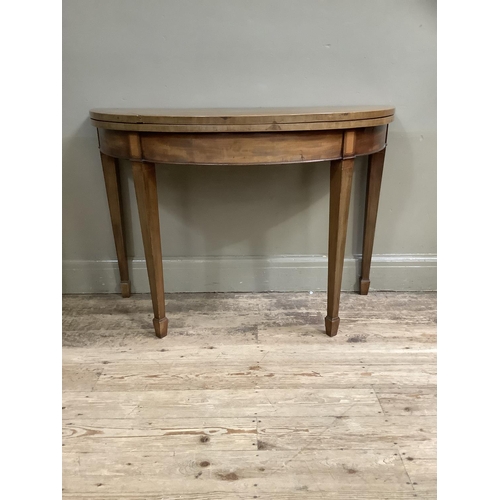 362 - A 19th century mahogany and cross banded demi lune card table inlaid with a shell paterae, on square... 