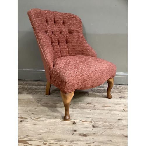 367 - A button back low set chair upholstered in deep coral and on cabriole legs