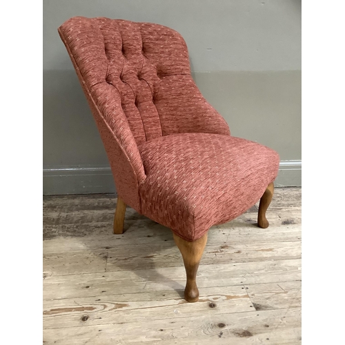 367 - A button back low set chair upholstered in deep coral and on cabriole legs