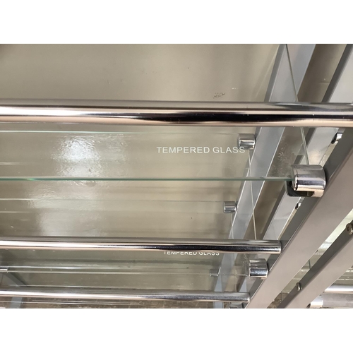 179 - A pair of grey metal chrome and tempered glass open shelves for DVD's, 60cm wide x 100cm high.