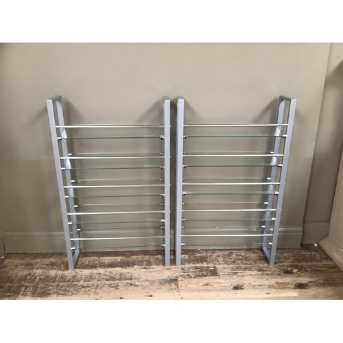 179 - A pair of grey metal chrome and tempered glass open shelves for DVD's, 60cm wide x 100cm high.