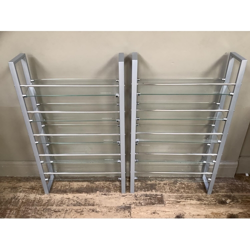 179 - A pair of grey metal chrome and tempered glass open shelves for DVD's, 60cm wide x 100cm high.