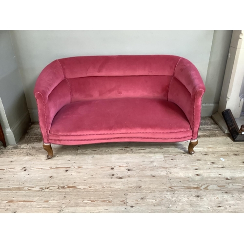 190 - An Edwardian two seater sofa with serpentine seat rail upholstered in pink velvet on short cabriole ... 