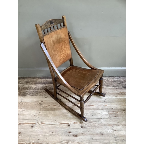 195 - A Victorian polished beech rocking chair with embossed panel for back and seat