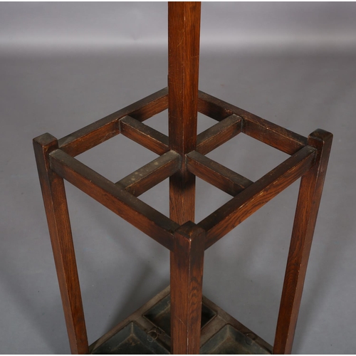 133 - An oak hall stand c.1930s, with four hat and coat pegs, the square section base with drip trays for,... 