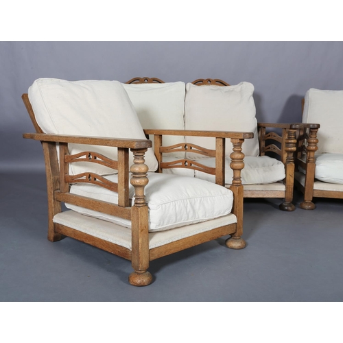 153 - An oak framed suite c.1920s, the two seater sofa having a double arched and pierced back, the arm pa... 