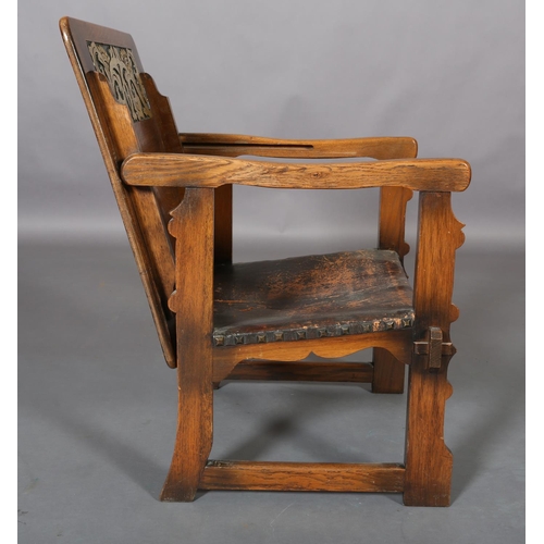 156 - An oak monk's chair c.1920s having a fold down foliate carved panel back, hide seat, on square mould... 