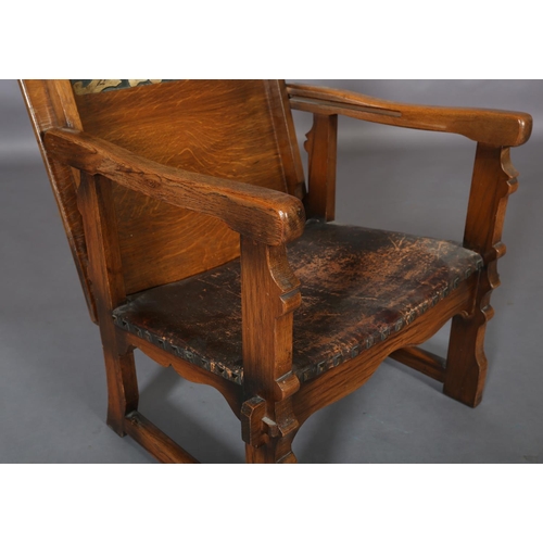 156 - An oak monk's chair c.1920s having a fold down foliate carved panel back, hide seat, on square mould... 