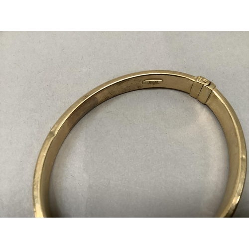 379 - A stiff hinged bangle, concave hollow tube in yellow metal (tests as 9ct gold), approximate weight 9... 