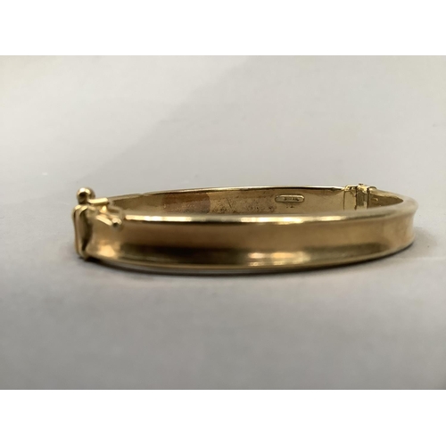 379 - A stiff hinged bangle, concave hollow tube in yellow metal (tests as 9ct gold), approximate weight 9... 