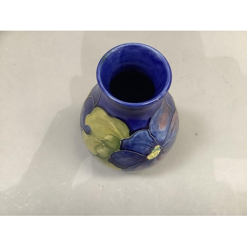 80 - A Moorcroft vase painted and tube lined with clematis pattern in shades of mauve, blue and green on ... 