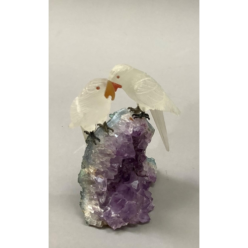 91 - Three Brazilian specimen mineral sculptures of a pair of parakeets perched on a rock, 11.5cm high, a... 